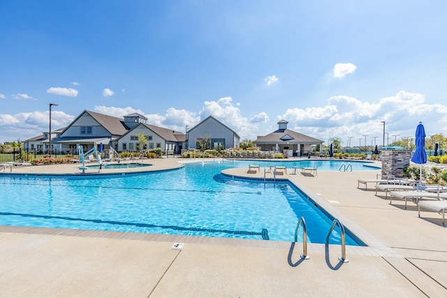 community pool with fence and a patio