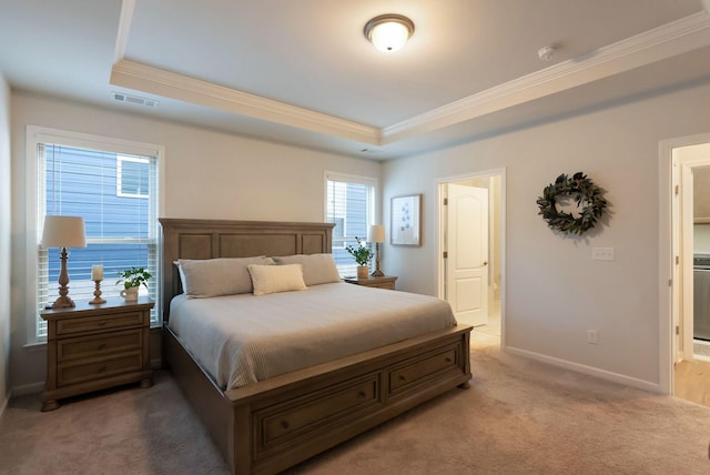 bedroom featuring ornamental molding, light carpet, a tray ceiling, baseboards, and ensuite bathroom