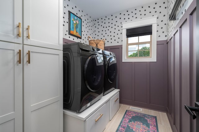 144 Autumn Crk, Lebanon, TN 37087 - laundry area featuring washer and dryer, cabinet space, a wainscoted wall, and wallpapered walls