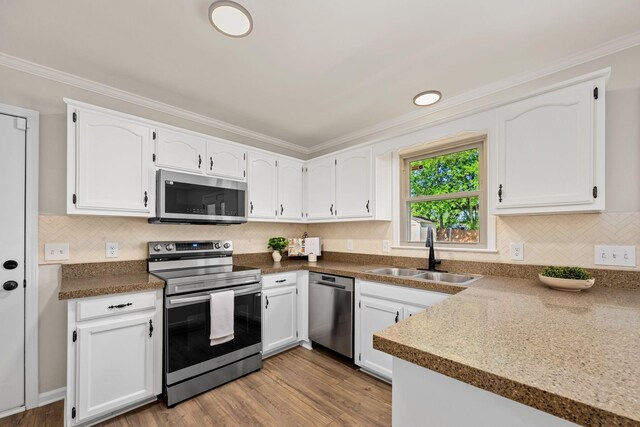 1643 Windy Meadow Dr, Christiana, TN 37037 - kitchen featuring stainless steel appliances, a sink, white cabinetry, ornamental molding, and decorative backsplash