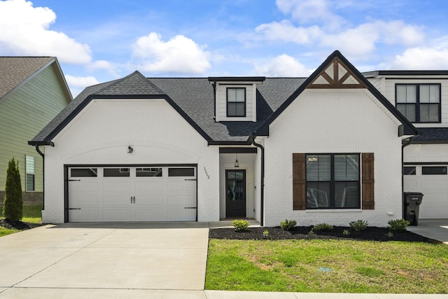 1112 Malinda Ln, Greenbrier, TN 37073 - view of front facade featuring a shingled roof, brick siding, concrete driveway, an attached garage, and a front lawn