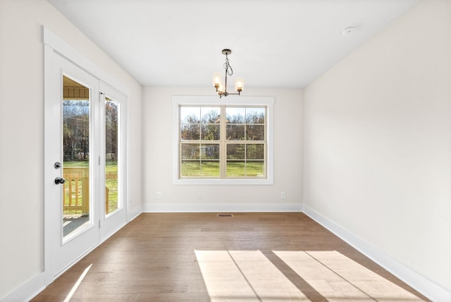 1936 Flats Rd, Cunningham, TN 37052 - unfurnished dining area with a chandelier, baseboards, and wood finished floors