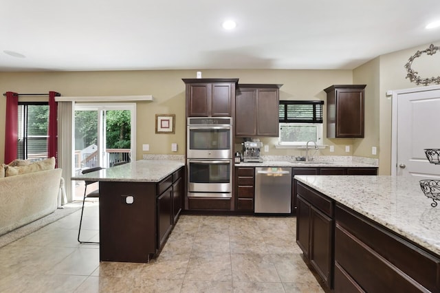 kitchen featuring appliances with stainless steel finishes, a sink, healthy amount of natural light, a peninsula, and recessed lighting