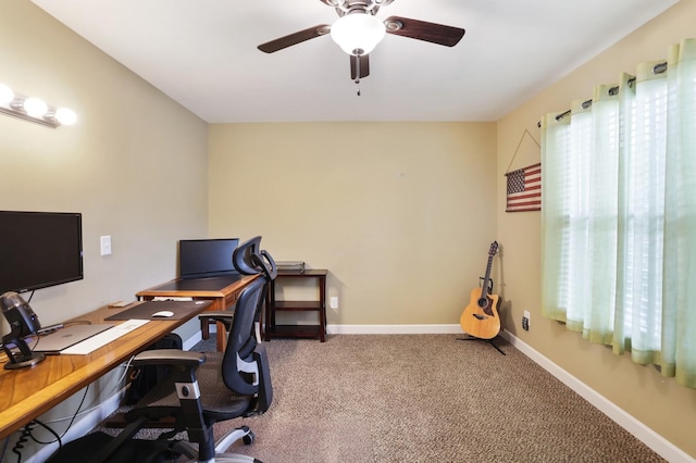 carpeted office space with ceiling fan and baseboards