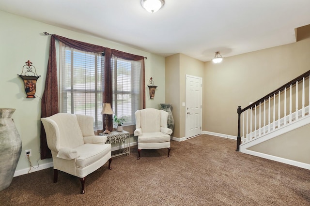 sitting room featuring carpet, stairway, and baseboards