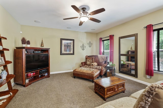 carpeted living room with ceiling fan, plenty of natural light, and baseboards