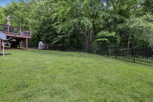view of yard with a shed, an outbuilding, and a deck