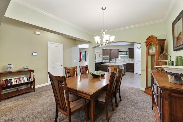 dining room with a chandelier, ornamental molding, dark colored carpet, arched walkways, and baseboards
