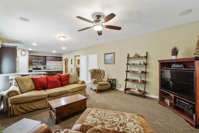 carpeted living room featuring a ceiling fan, baseboards, and recessed lighting