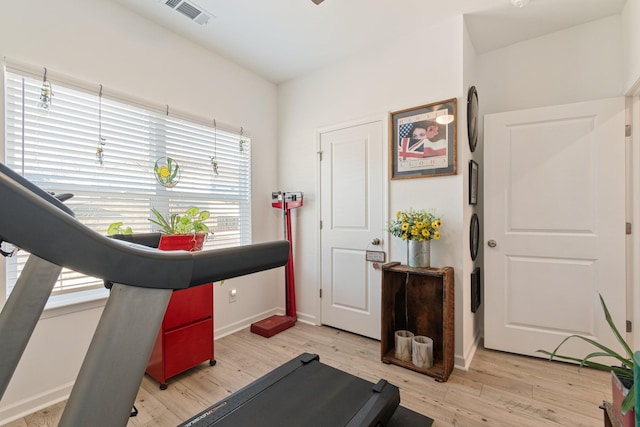 exercise area with light wood-style floors and baseboards