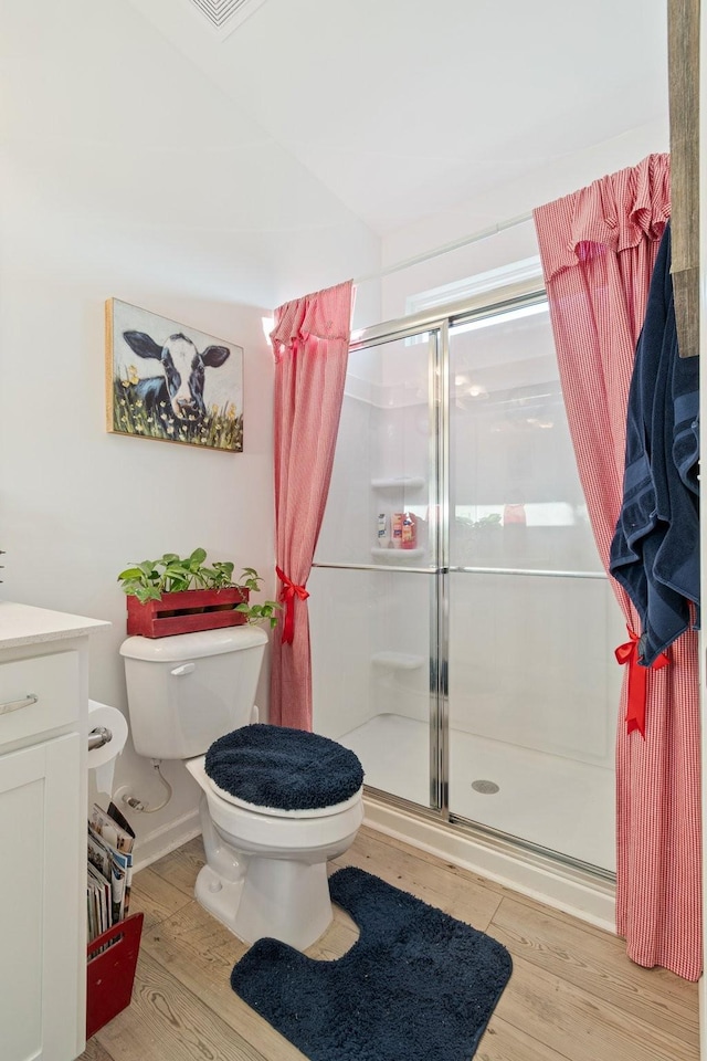 full bathroom with toilet, a stall shower, wood finished floors, and vanity