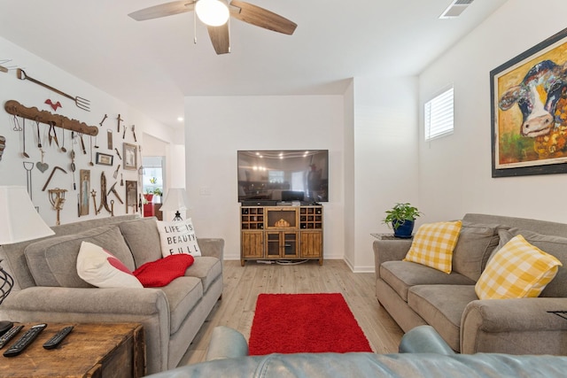 living room with wood finished floors, a ceiling fan, and baseboards