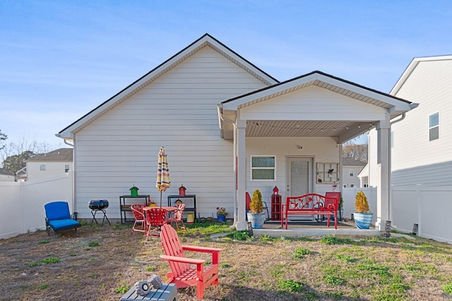 back of property with fence and a porch