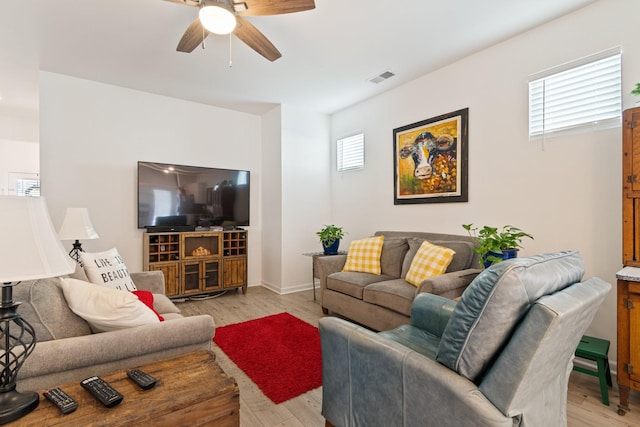 living area with a ceiling fan, healthy amount of natural light, and light wood finished floors