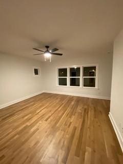 spare room featuring wood finished floors, baseboards, and a ceiling fan
