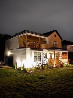 back of property with a balcony and a yard