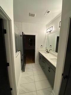 bathroom with double vanity and tile patterned flooring