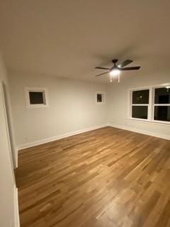 empty room with wood finished floors, ceiling fan, and baseboards