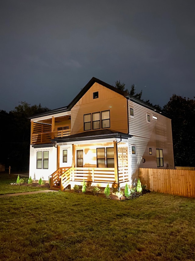 back of house at twilight featuring a balcony