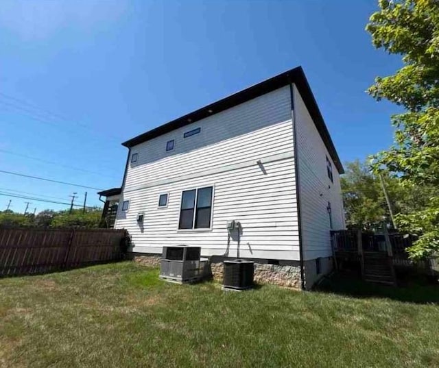 back of house featuring cooling unit and a deck