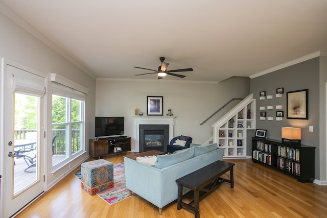 1552 Liberty Pike, Franklin, TN 37067 - living room featuring wood finished floors, a glass covered fireplace, ornamental molding, ceiling fan, and stairs