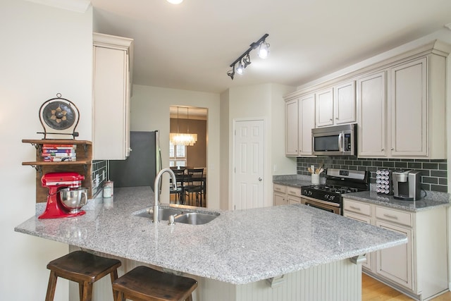 1552 Liberty Pike, Franklin, TN 37067 - kitchen featuring a sink, stainless steel appliances, a peninsula, a breakfast bar area, and backsplash