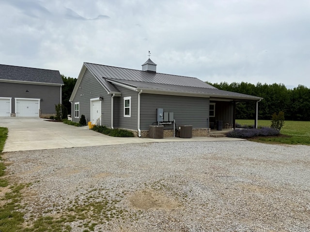 69 Meadows Rd, Hillsboro, TN 37342 - rear view of property with driveway, central air condition unit, metal roof, and a garage