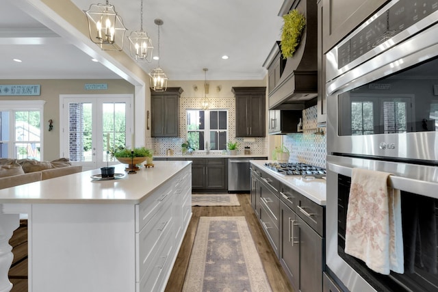 69 Meadows Rd, Hillsboro, TN 37342 - kitchen with stainless steel appliances, a chandelier, light countertops, wood finished floors, and decorative backsplash