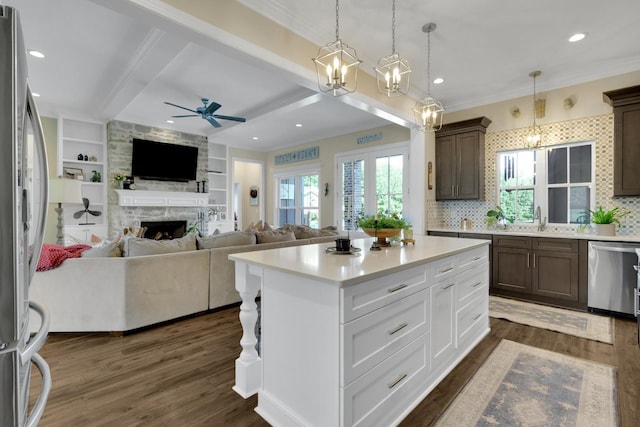 69 Meadows Rd, Hillsboro, TN 37342 - kitchen with stainless steel appliances, open floor plan, ornamental molding, a stone fireplace, and light countertops