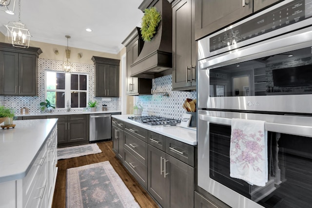 69 Meadows Rd, Hillsboro, TN 37342 - kitchen with appliances with stainless steel finishes, a chandelier, custom exhaust hood, light countertops, and dark wood-style floors