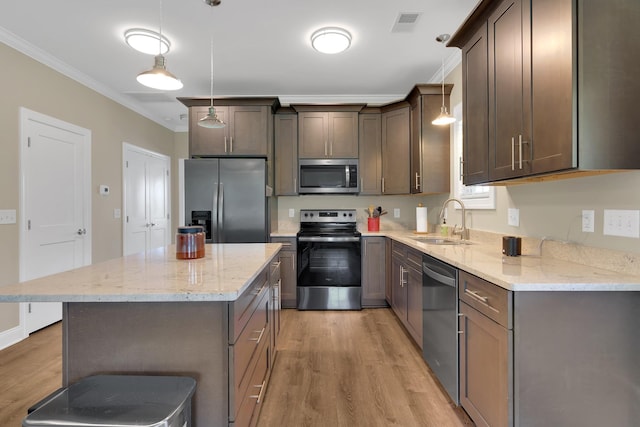 69 Meadows Rd, Hillsboro, TN 37342 - kitchen featuring appliances with stainless steel finishes, ornamental molding, light wood-type flooring, a center island, and light stone counters