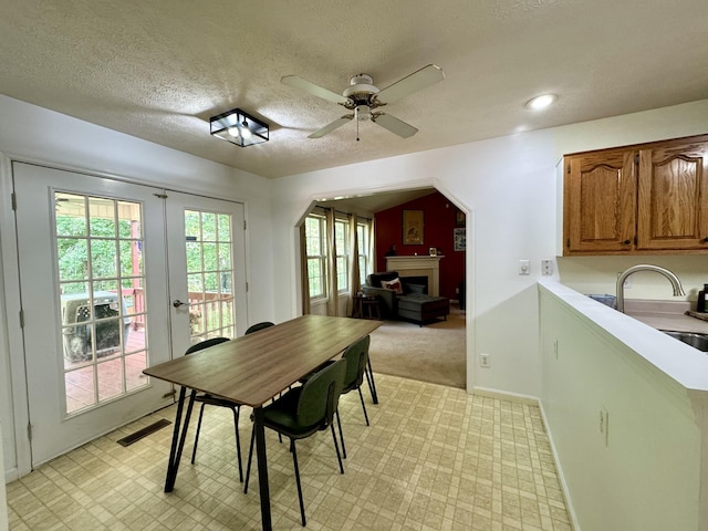 130 Jordan Ln, Hohenwald, TN 38462 - dining area featuring a fireplace, a ceiling fan, a textured ceiling, french doors, and baseboards