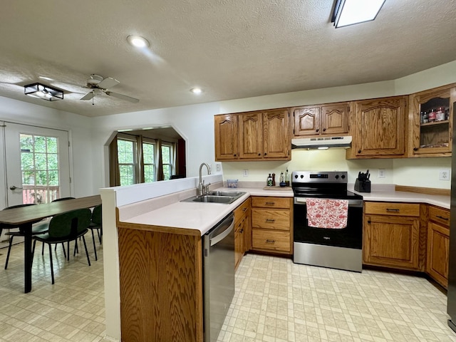 130 Jordan Ln, Hohenwald, TN 38462 - kitchen with stainless steel appliances, a sink, under cabinet range hood, light flooring, and a textured ceiling