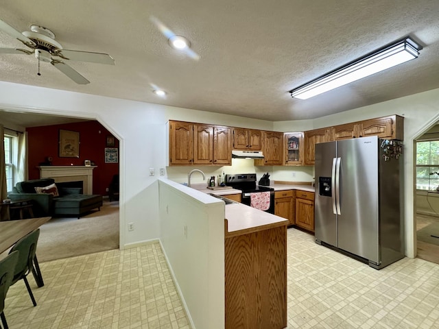 130 Jordan Ln, Hohenwald, TN 38462 - kitchen with stainless steel refrigerator with ice dispenser, electric range, under cabinet range hood, a peninsula, and brown cabinets