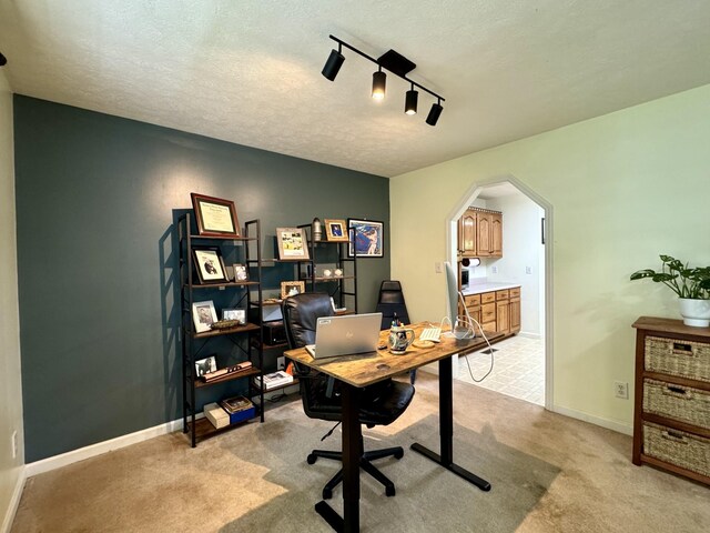 130 Jordan Ln, Hohenwald, TN 38462 - office area featuring arched walkways, light colored carpet, a textured ceiling, track lighting, and baseboards