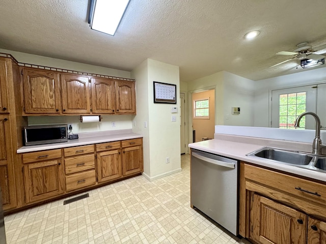130 Jordan Ln, Hohenwald, TN 38462 - kitchen with stainless steel appliances, a sink, brown cabinets, light countertops, and a textured ceiling
