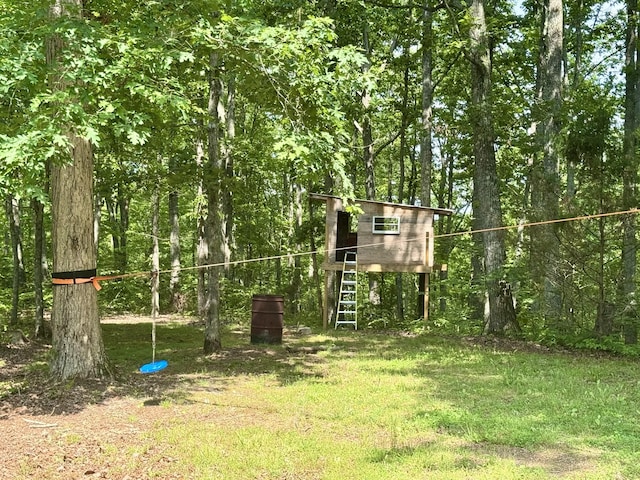 130 Jordan Ln, Hohenwald, TN 38462 - view of playground with an outdoor structure, a lawn, a forest view, and exterior structure