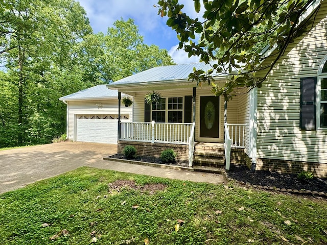 130 Jordan Ln, Hohenwald, TN 38462 - view of front facade featuring a porch, driveway, a garage, and metal roof