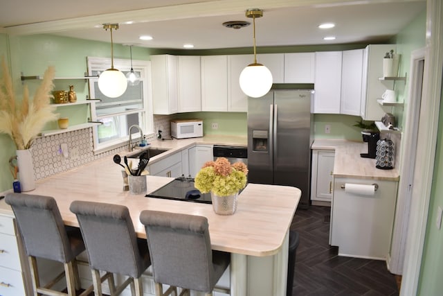 kitchen with appliances with stainless steel finishes, open shelves, a peninsula, a sink, and tasteful backsplash