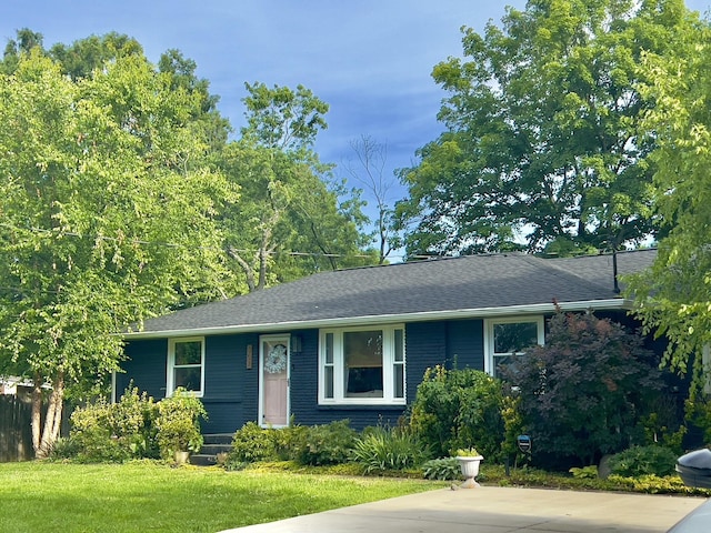view of front of property with a front yard and a shingled roof
