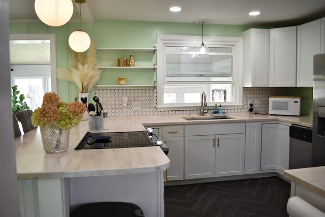 kitchen with stainless steel appliances, a sink, light countertops, backsplash, and recessed lighting