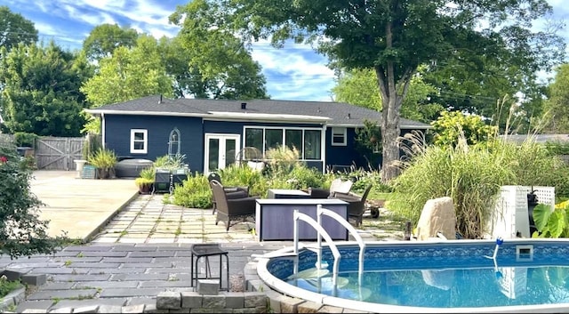 rear view of house with a patio, an outdoor pool, french doors, outdoor lounge area, and fence