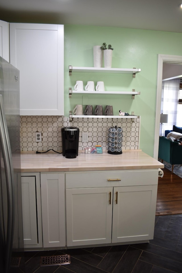bar area featuring freestanding refrigerator and backsplash