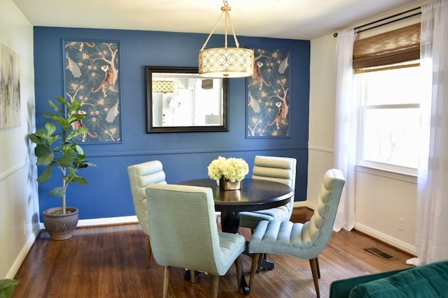 dining room featuring wood finished floors and baseboards