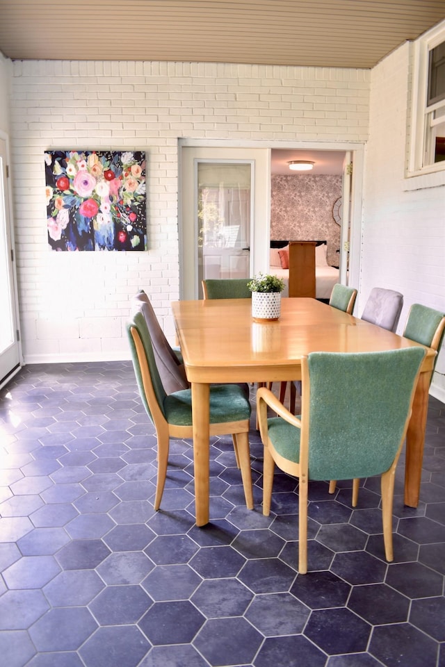 dining area featuring brick wall