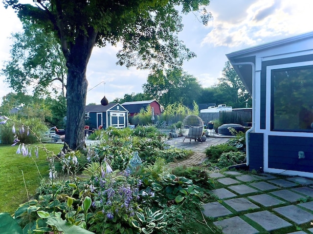 view of yard featuring a patio area, an outbuilding, and a shed