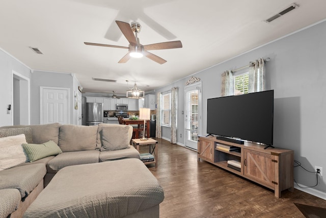 living area with ornamental molding, a ceiling fan, dark wood finished floors, and baseboards