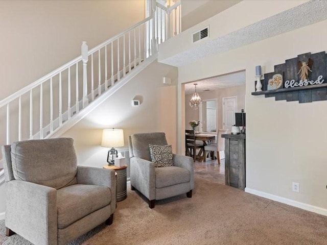 living area with stairway, carpet, a chandelier, and baseboards