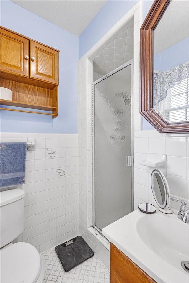 505 Kindel Dr, Decherd, TN 37324 - full bath with tile walls, a stall shower, toilet, vanity, and a wainscoted wall