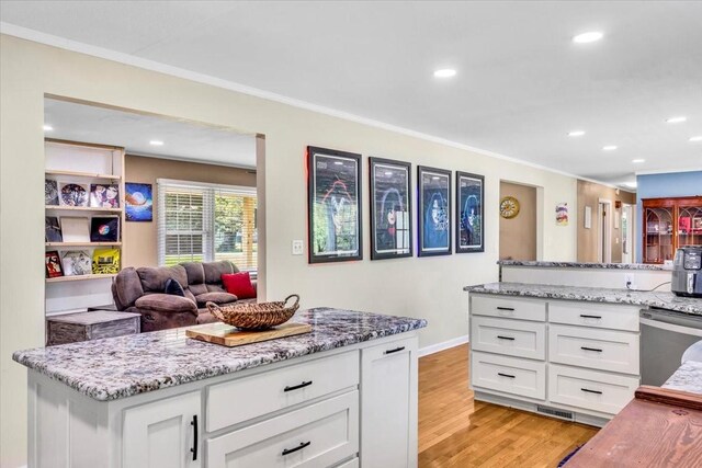 505 Kindel Dr, Decherd, TN 37324 - kitchen with light wood-type flooring, white cabinets, stainless steel dishwasher, light stone countertops, and ornamental molding